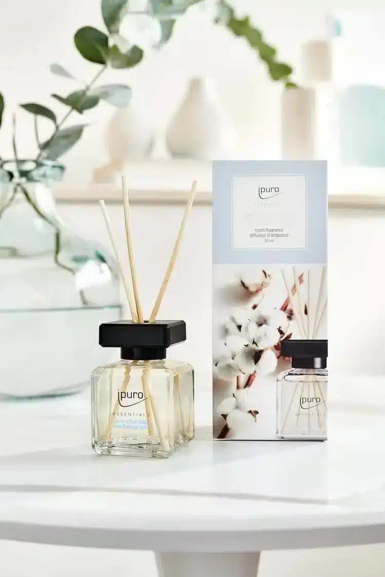 ipuro Essentials Cotton Fields Duftstäbchen mit Verpackung, Baumwollzweigen und Eukalyptus auf weißem Tisch