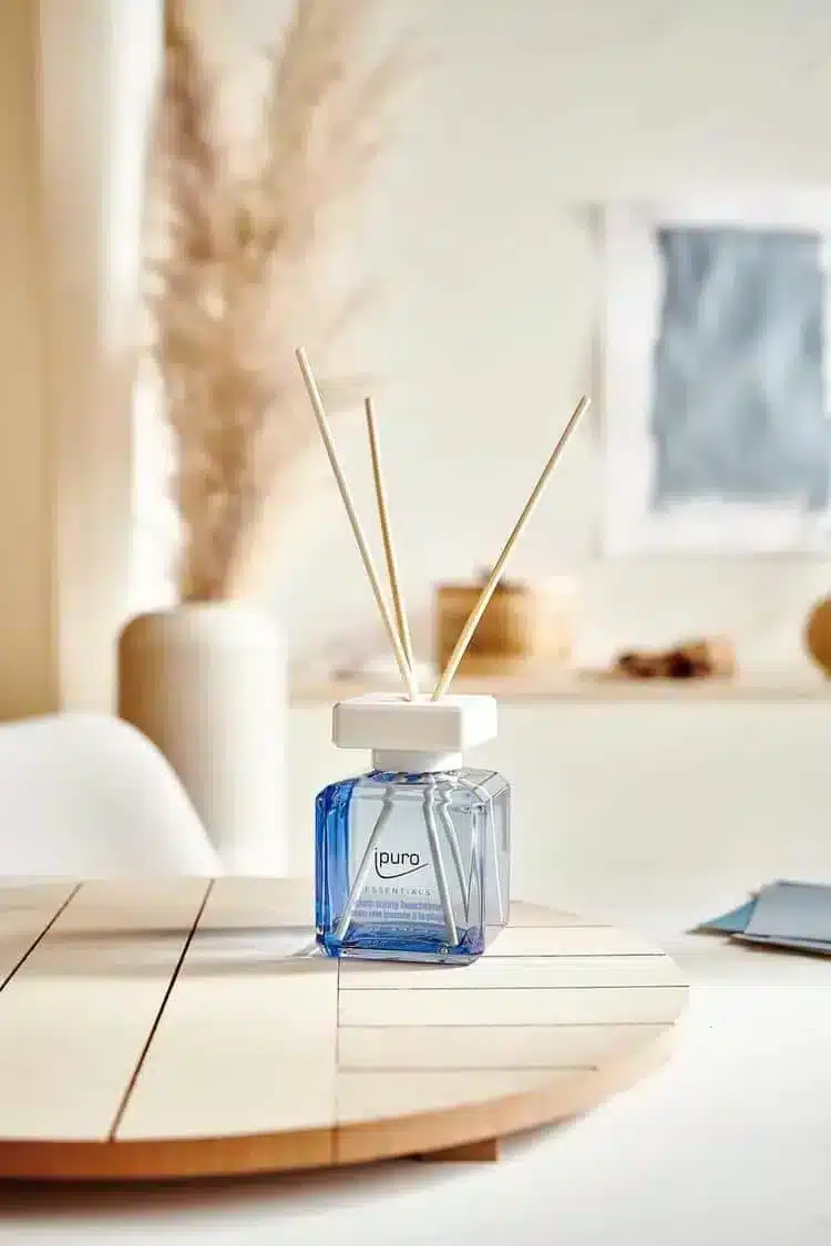Ipuro Essentials Sunny Beachtime Duftstäbchen in blauer Flasche auf Holztisch mit Pampasgras