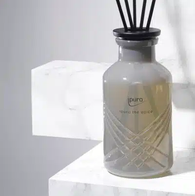 ipuro Exclusive thé épicé Duftstäbchen 240ml in grauer Glasflasche auf weißem Marmor, Nahaufnahme